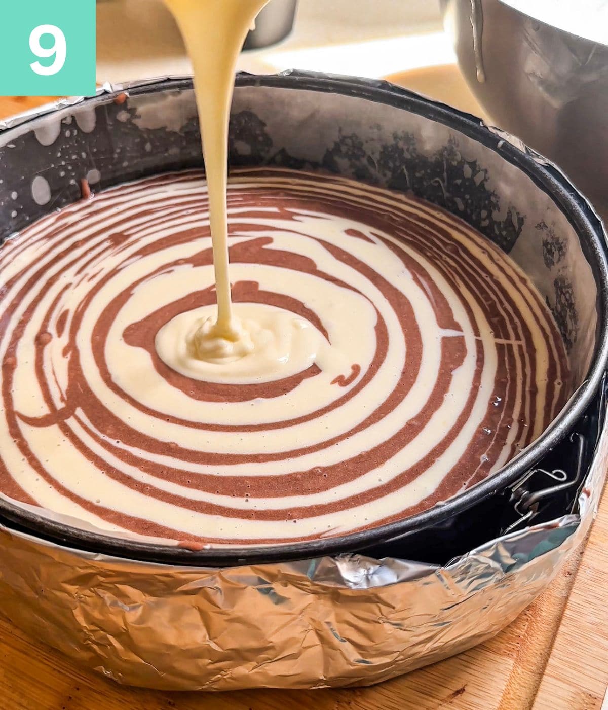 Creating a zebra pattern from the batter by dropping both batters alternatively into the centre of the baking pan.