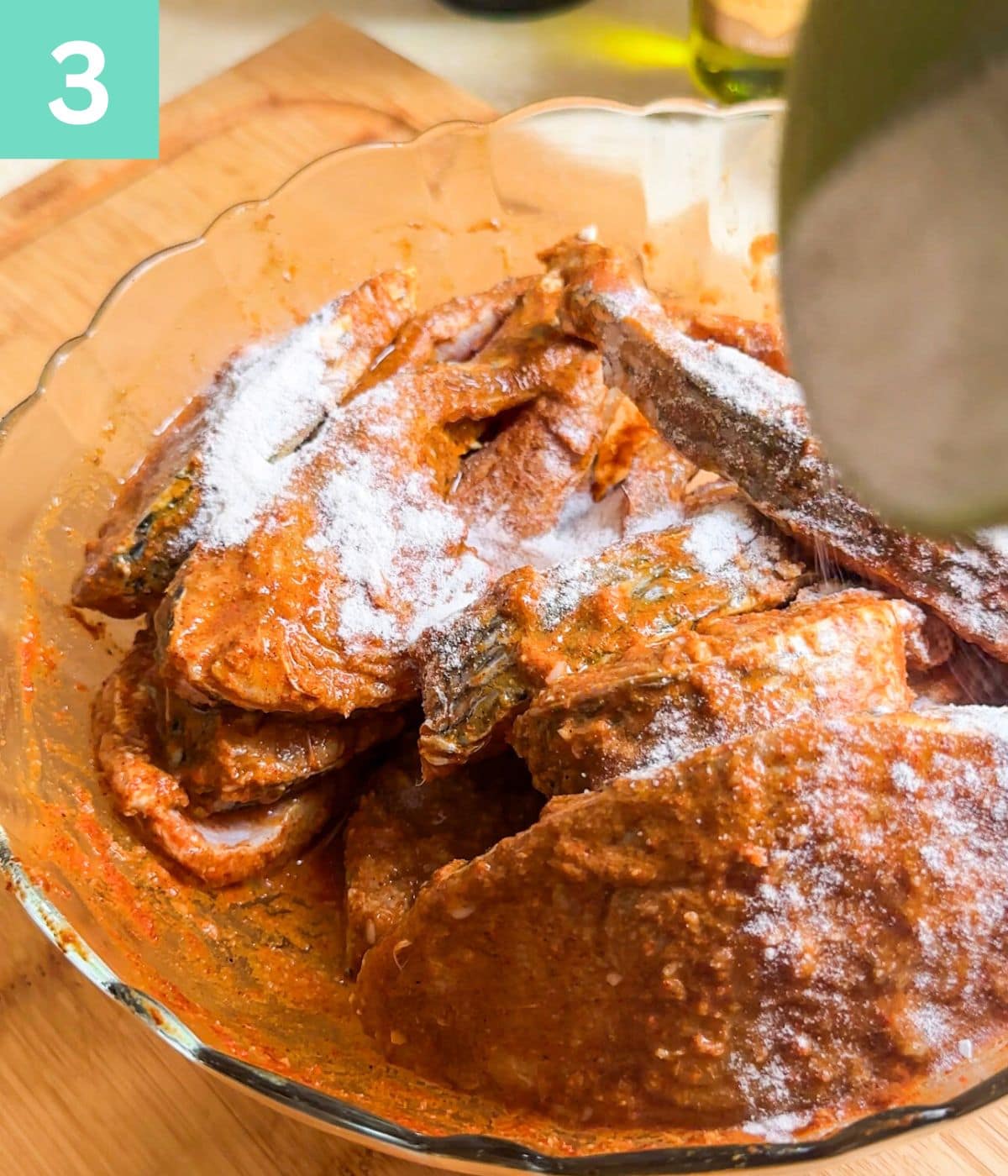 adding rice flour to marinated fish steaks.