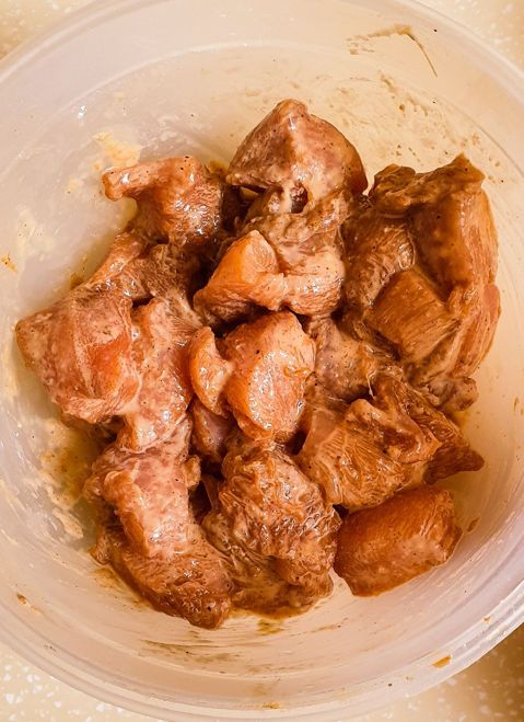 Marinated chicken cubes in a plastic bowl