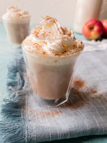 apple cinnamon latte in a glass topped with cream