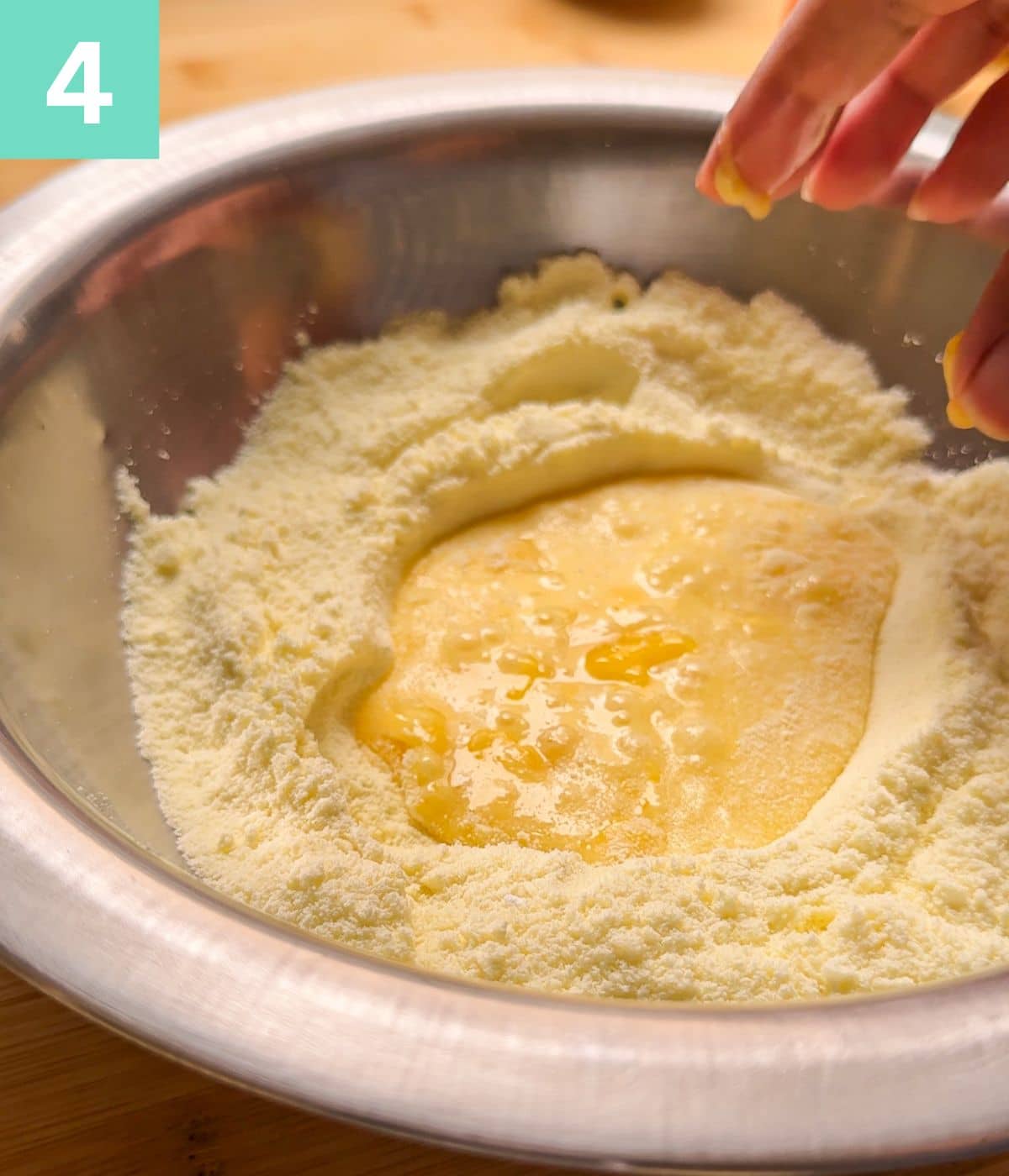 beaten eggs and ghee added to dry ingredients in a bowl.