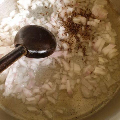 finely chopped onion with cumin seeds in oil 