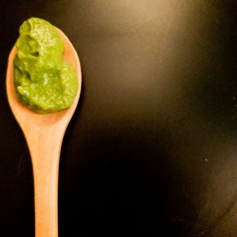 mint sauce on a wooden spoon on a black background