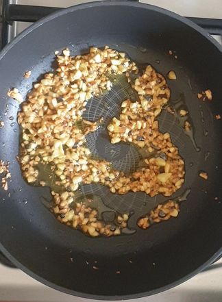 golden brown garlic in oil in a black wok