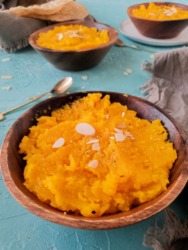 front view of suji ka halwa in a bowl with 2 similar bowls showing in the background