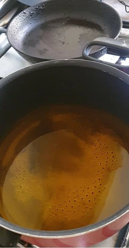 yellow colored water with sugar in it in a black pot