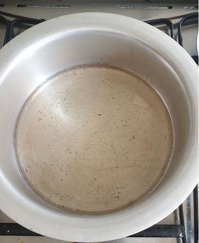 Cooking oil in a stainless steel pot/pateeli