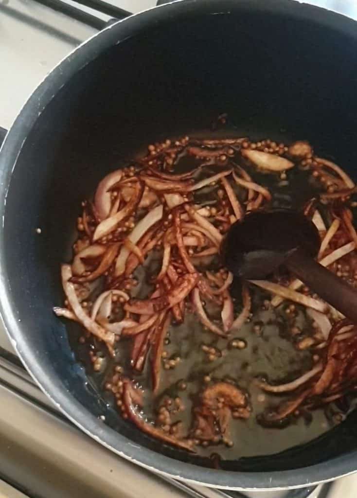 onion sliced fried to a brown color in a pot