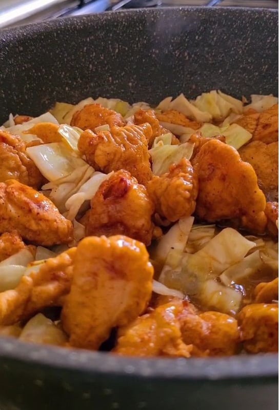 golden fried chicken cubes added in sauce and cabbage