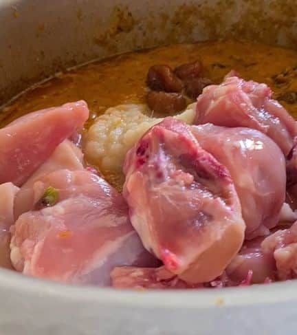 raw chicken pieces added to masala base
