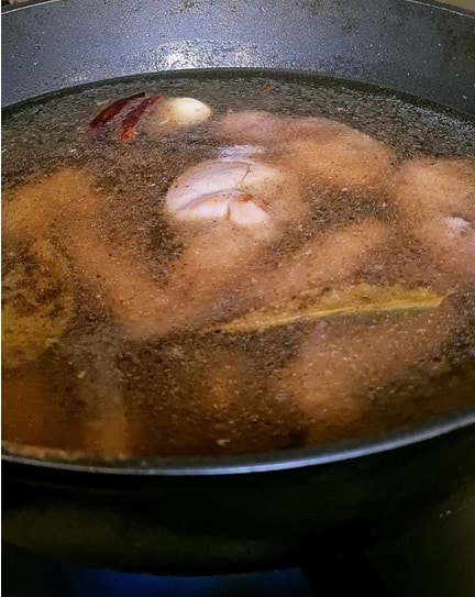 white bone in chicken immersed in seasoned water and droplets of oil