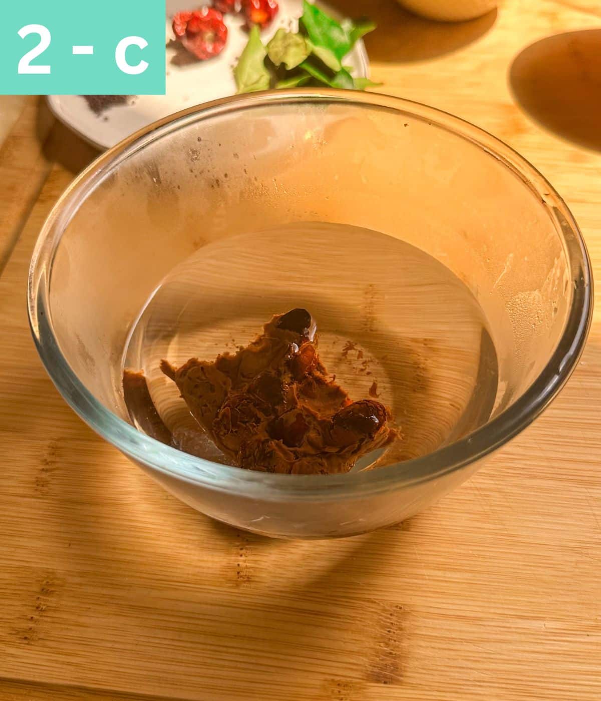 a small block of tamarind soaked in water in a bowl.