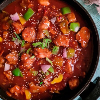 sweet and sour chicken with gravy in a black wok