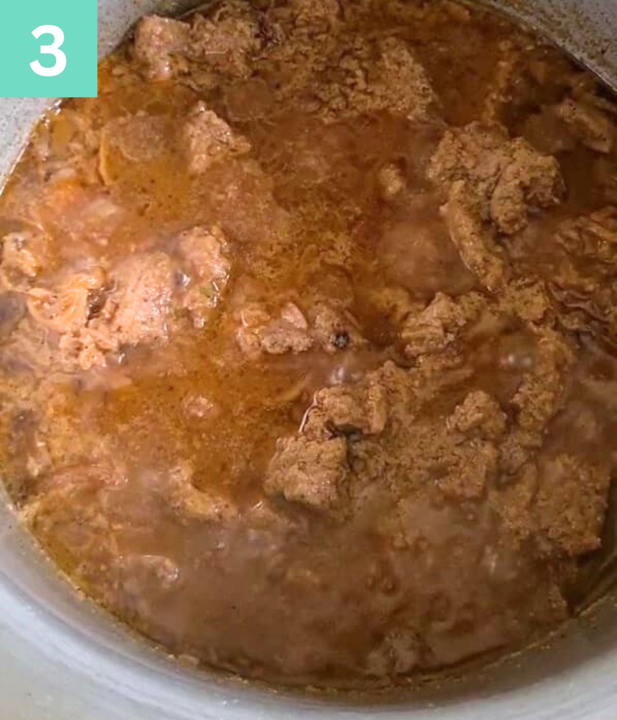 Beef being cooked down in pot.