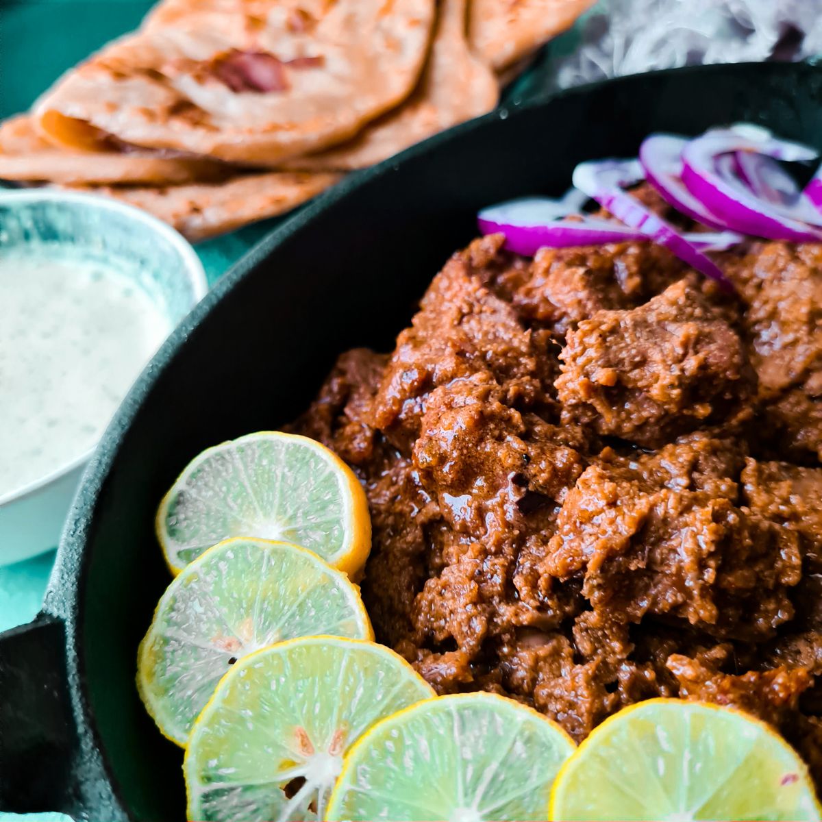 Beef handi kebabs served in a platter with lemon and onion slices.