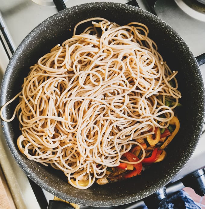 parboiled noodles added to black skillet