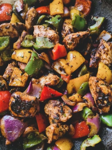 a close up shot of chicken stir fry in a pan