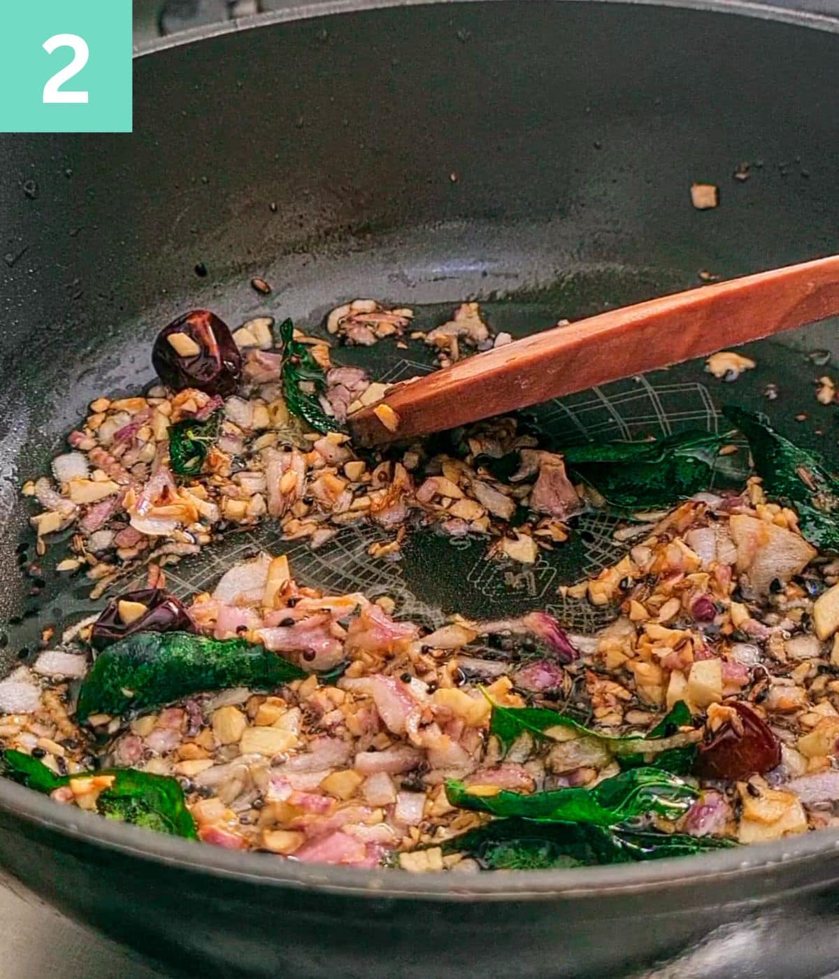 spices and onion turning golden brown in oil in a pan.