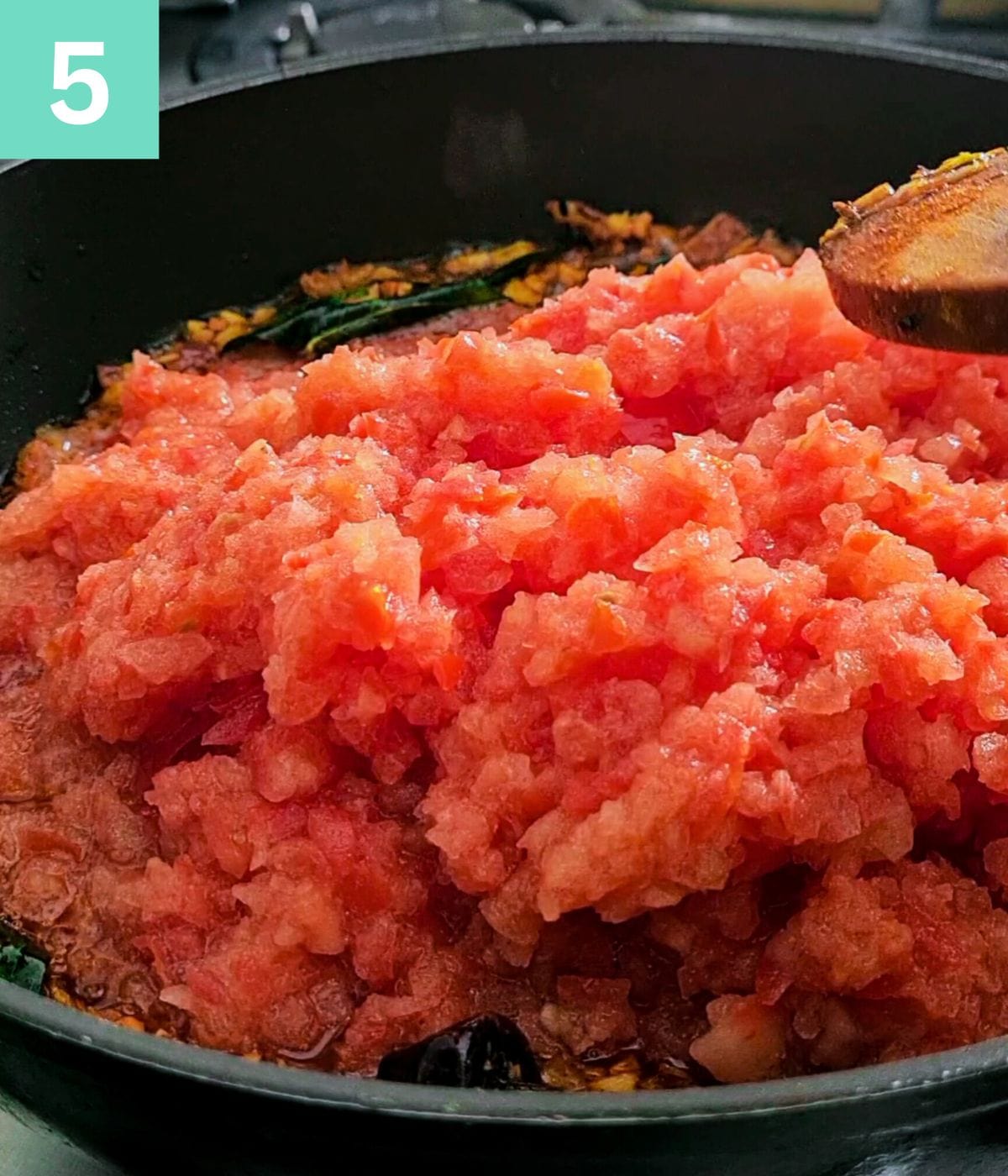 adding crushed tomatoes to the chutney base.