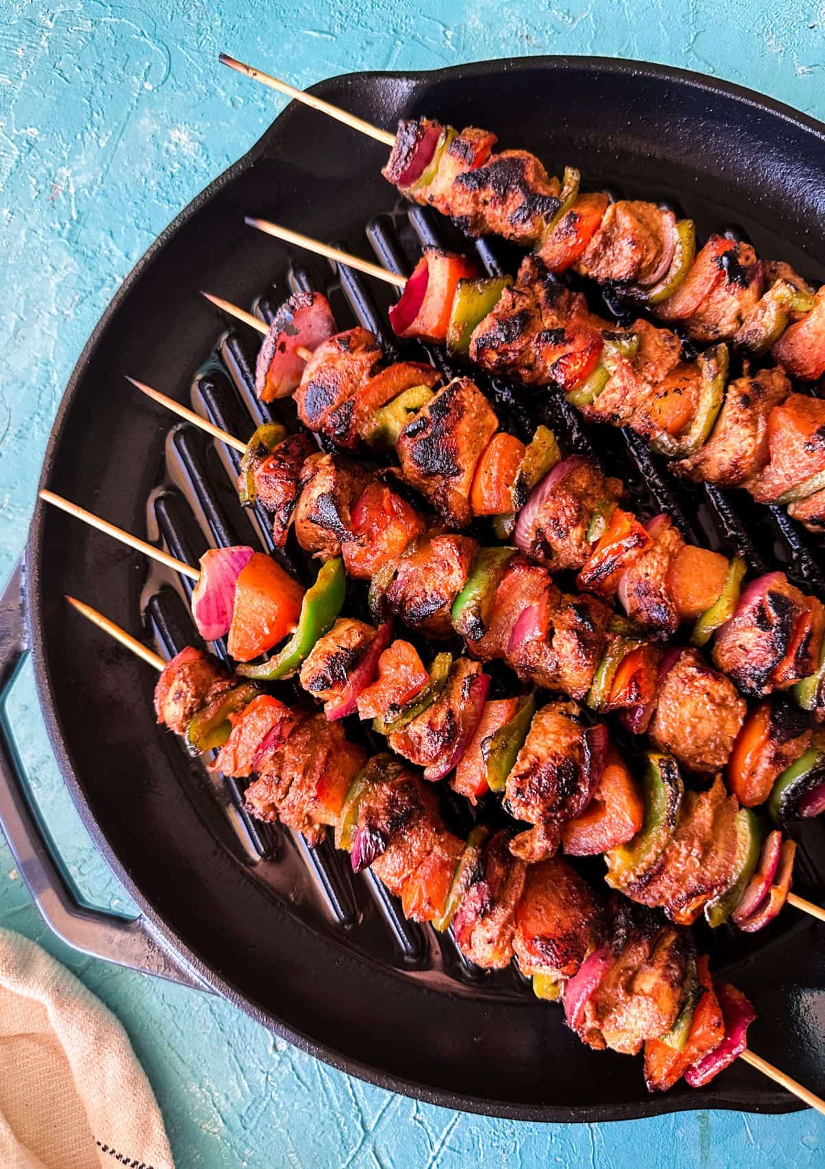chicken shashlik skewers served on a grill pan.