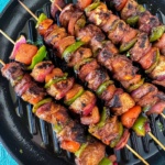 chicken shashlik skewers served on a grill pan.