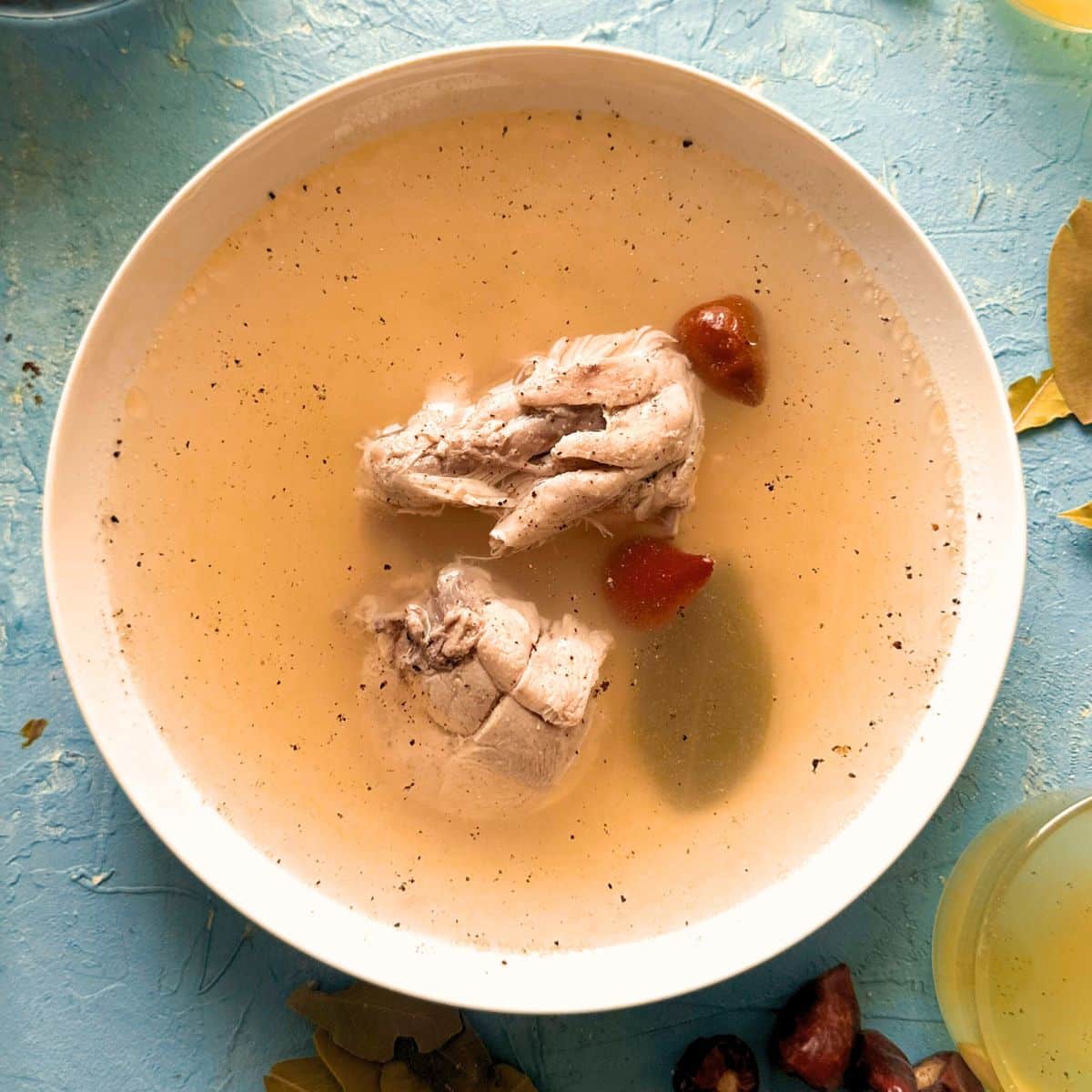 chicken broth served in a bowl with chicken pieces.