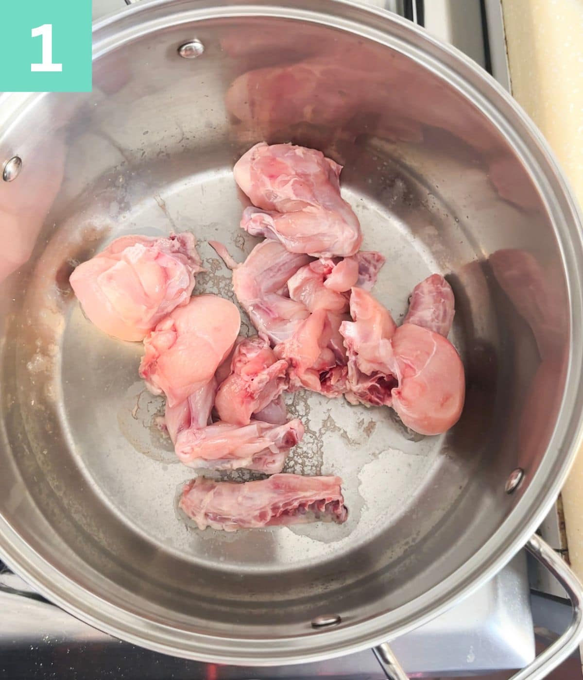 raw chicken pieces in a stockpot.